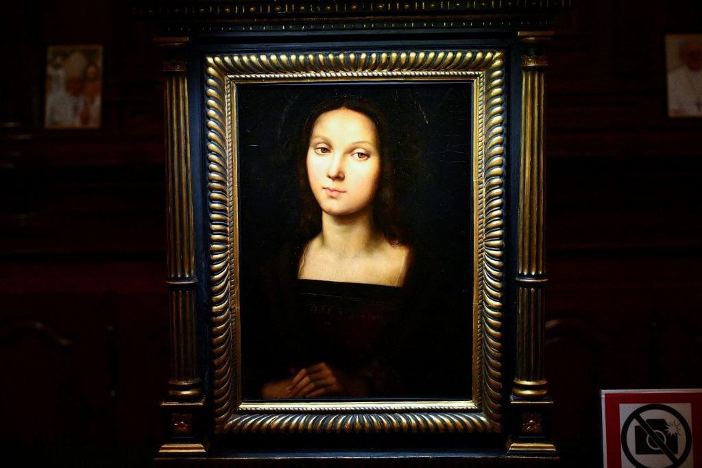 A portrait of a woman in plain dress, displayed in a gilded frame