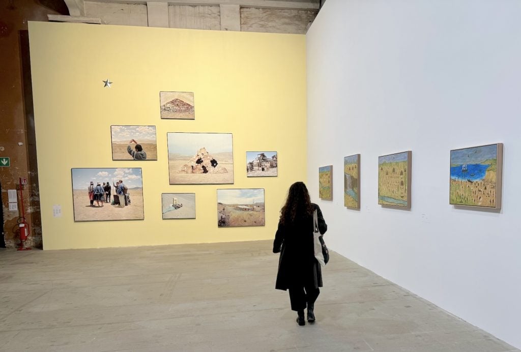 A suite of photos on one wall of a gallery, and a series of paintings of landscapes