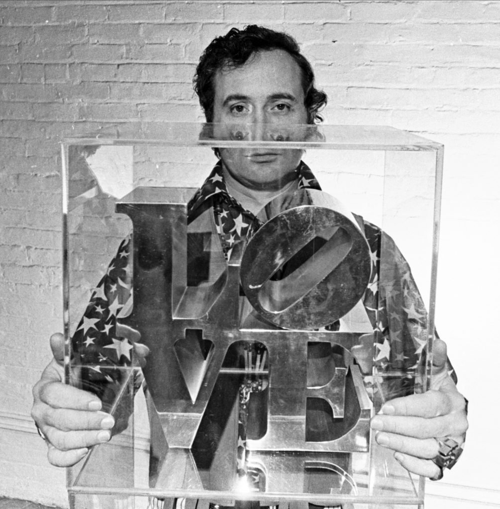 A man, artist Robert Indiana, holding a sculpture making up the word "LOVE"