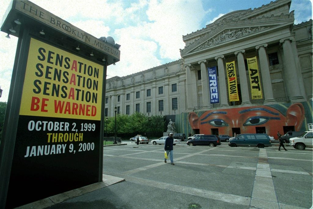 Posters for the sensation exhibitionyellow, red and black outside the Brooklyn Museum's Palladian facade.