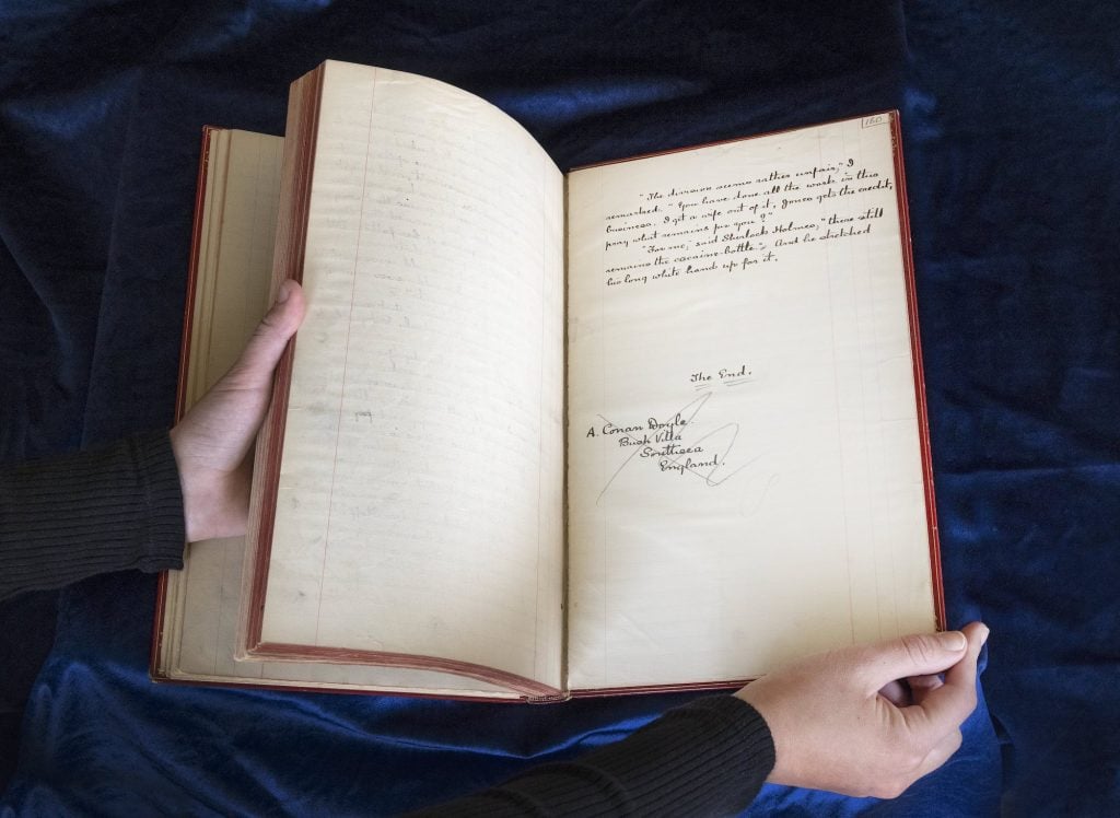Sir Arthur Conan Doyle's handwritten manuscript held open.