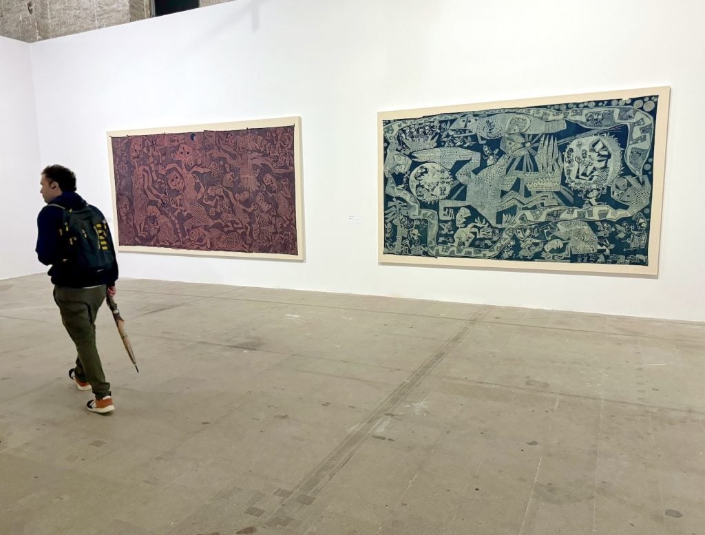 Two batik fabric works in a gallery