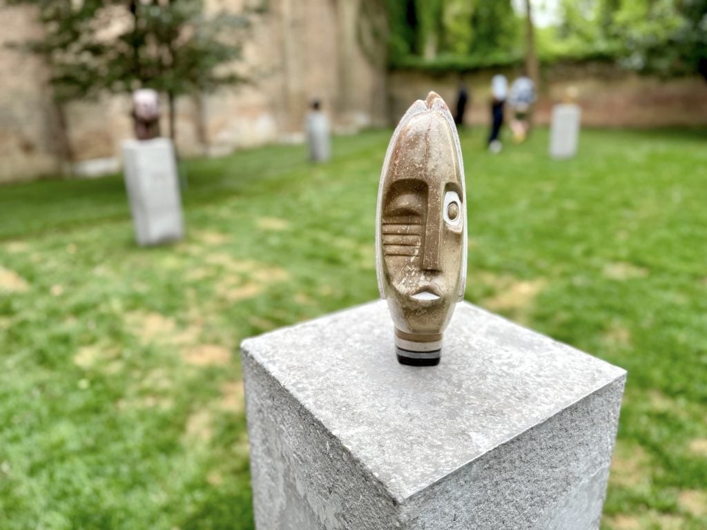 A sculpture of a face bisected so that it is different on each side down the middle