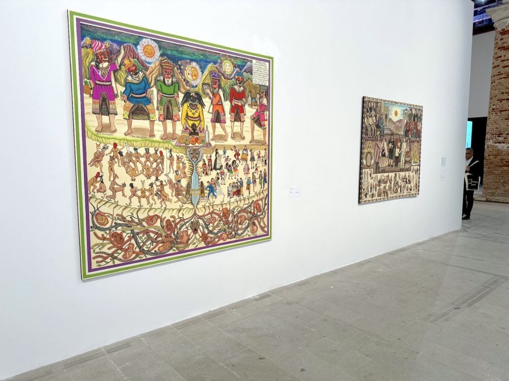 Two large, densely details paintings on a wall