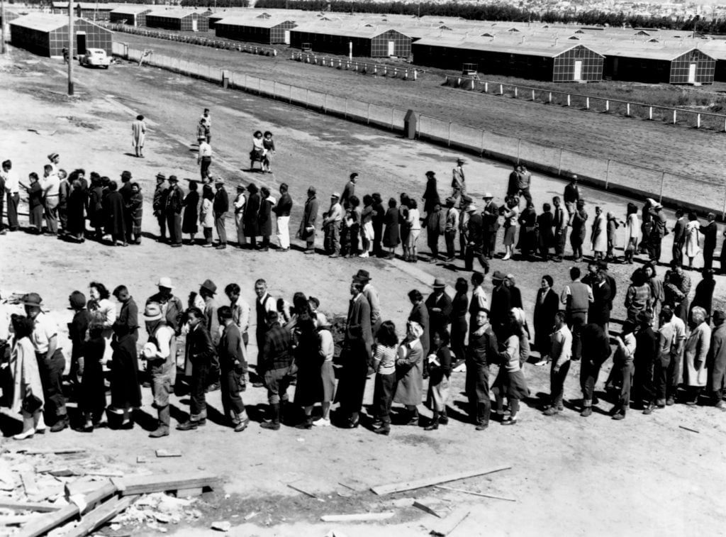 twwo lines of people waiting on a barren land strip, in black and white, photo by Dorothea Lange