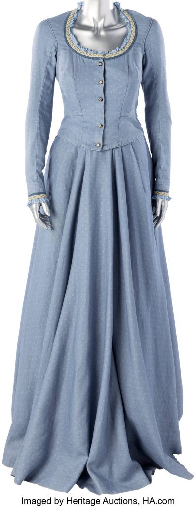 Photograph of a silver mannequin from the neck down, dressed in a simple light blue vintage country girl day dress