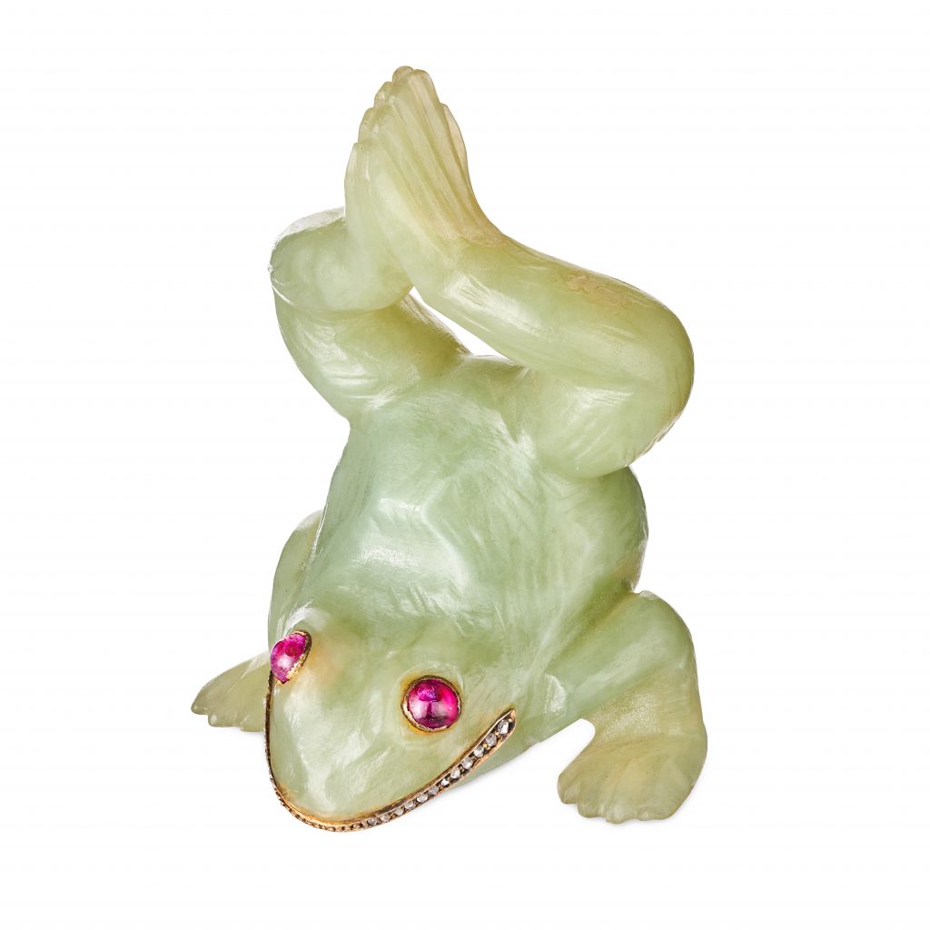 A light green carving of a frog doing a handstand, with pink ruby eyes and a mouth lined with diamonds. By Fabergé
