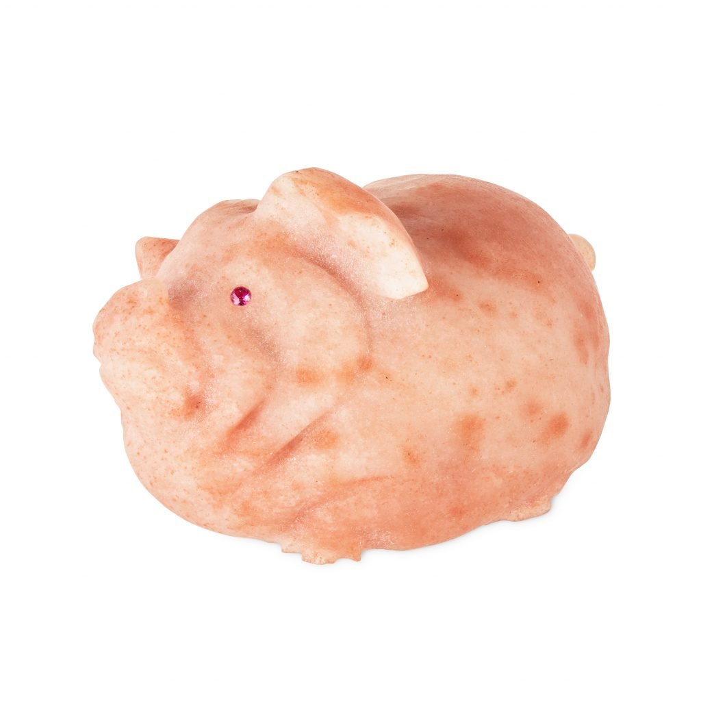 A pink carving of a pig with ruby eyes by Fabergé