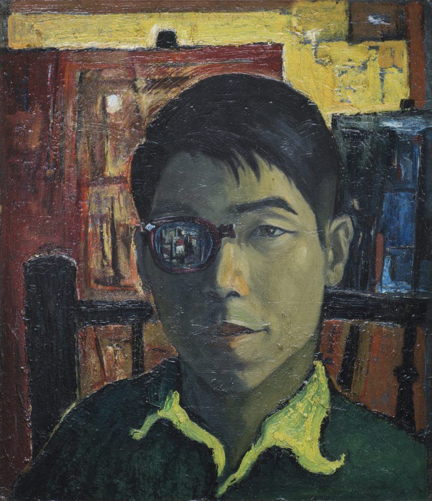 Headshot portrait of a man sitting in a wood chair with a monocle and a painting on an easel in the background.