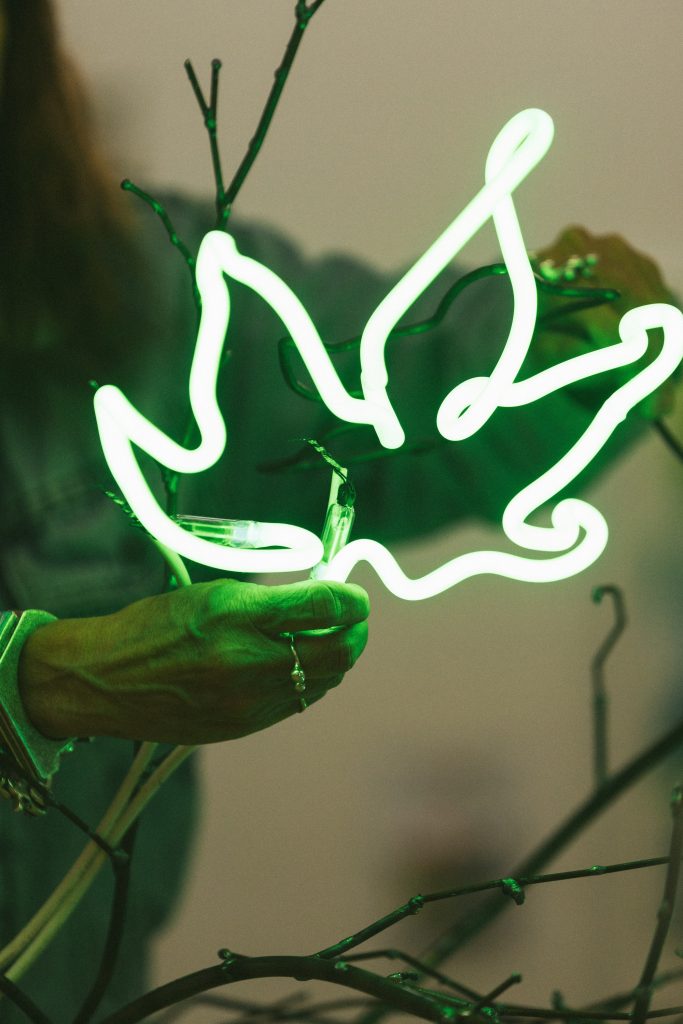 the artist working on a neon leaf sculpture element of her chandelier