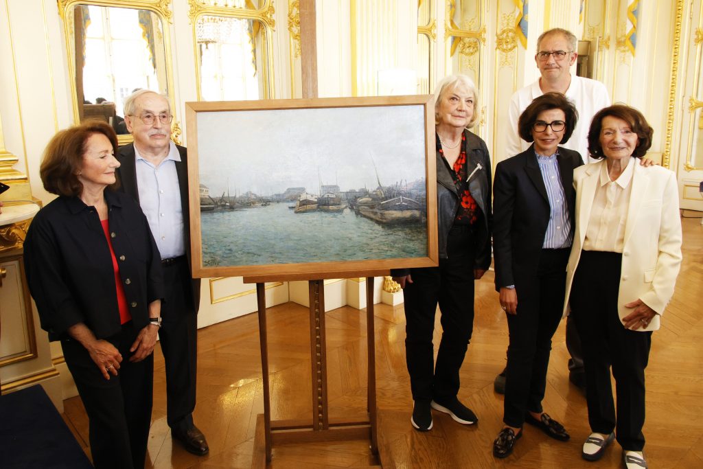 a group of people stand around a painting of a misty river scene in which boats can also be seen in a very fancy, old fashioned interior
