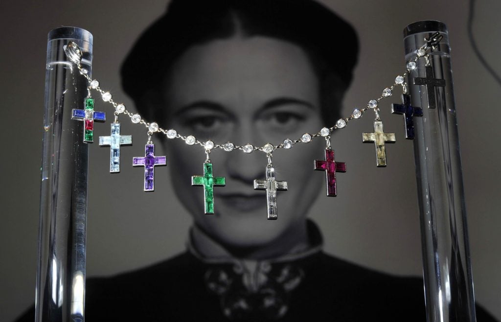 Colorful crosses on a diamond bracelet in front of a black and white picture of the duchess of windsor