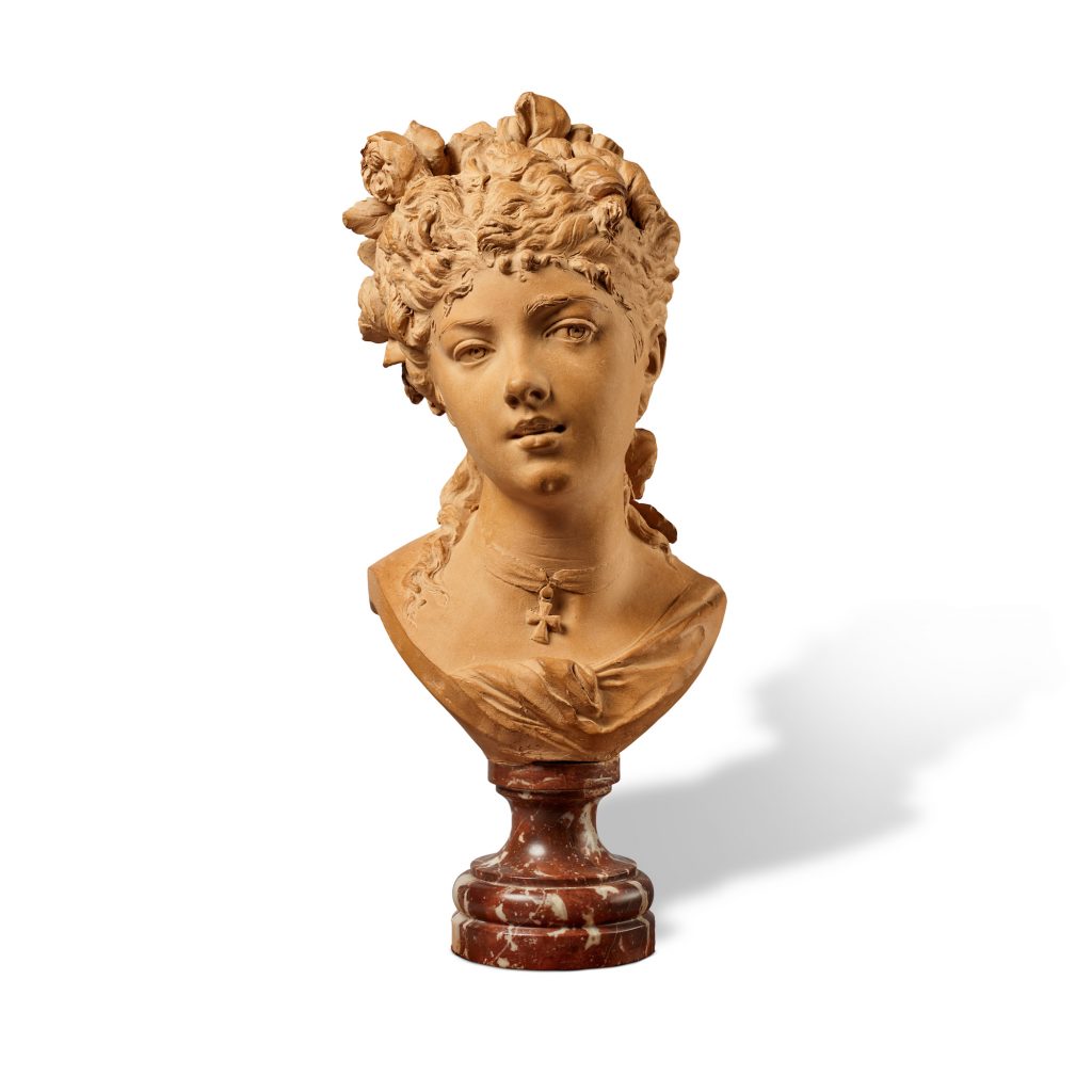 an image of a terracotta bust atop a marble plinth depicting a woman's head with roses in her hair