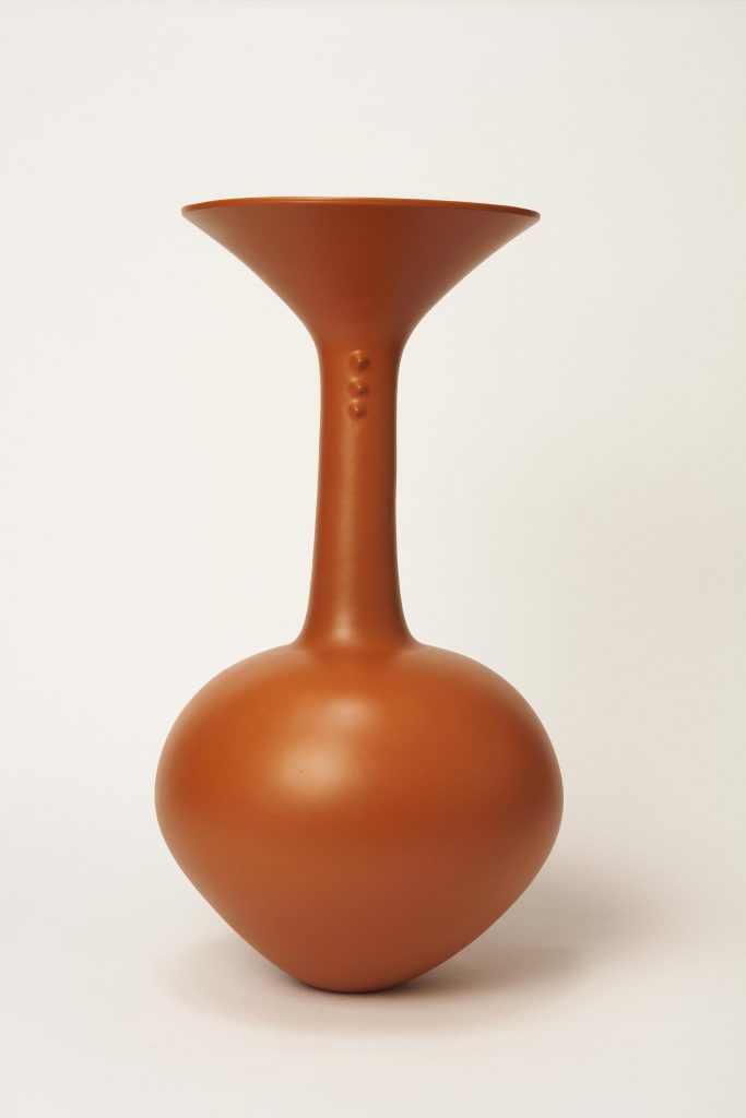 a terracotta vase with a round base, long neck and large lip, in front of a white background. By the ceramicist Magdalene Odundo. 