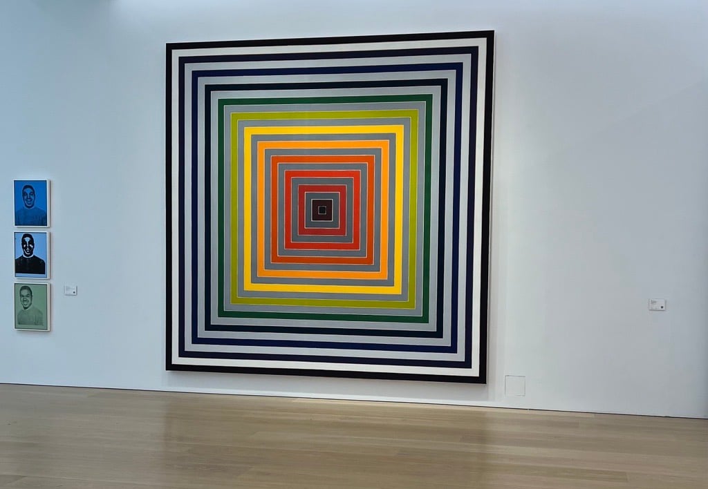 A square painting with concentric squares inside forming a sequence of colors in black, white, gray, yellow and red