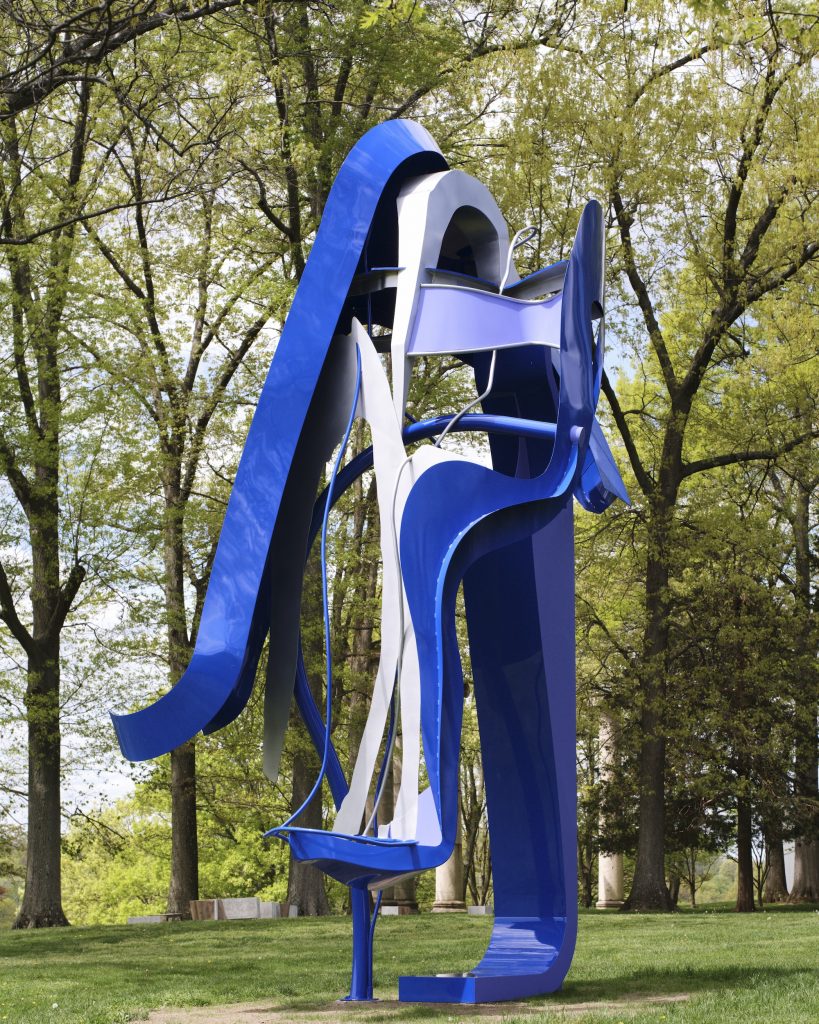 a vertical abstract outdoor sculpture with blue shapes