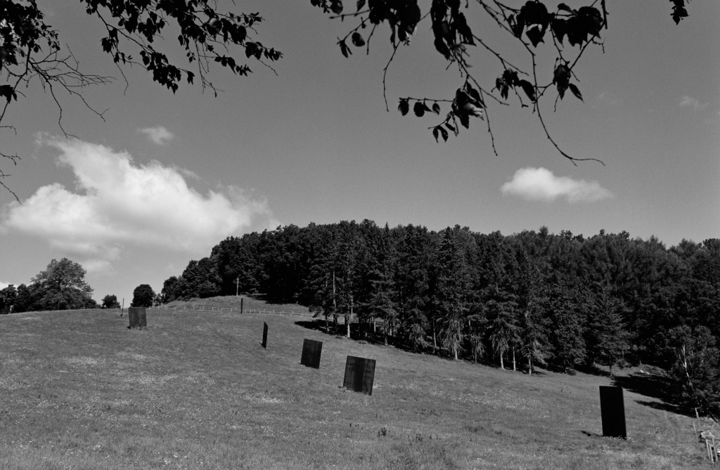 a hilly clearing with square iron sculptures protuding from the earth