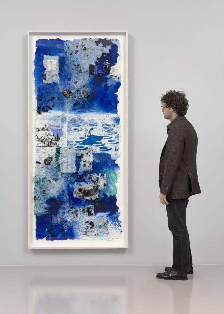 photograph of a man viewing a large scale mixed media painting