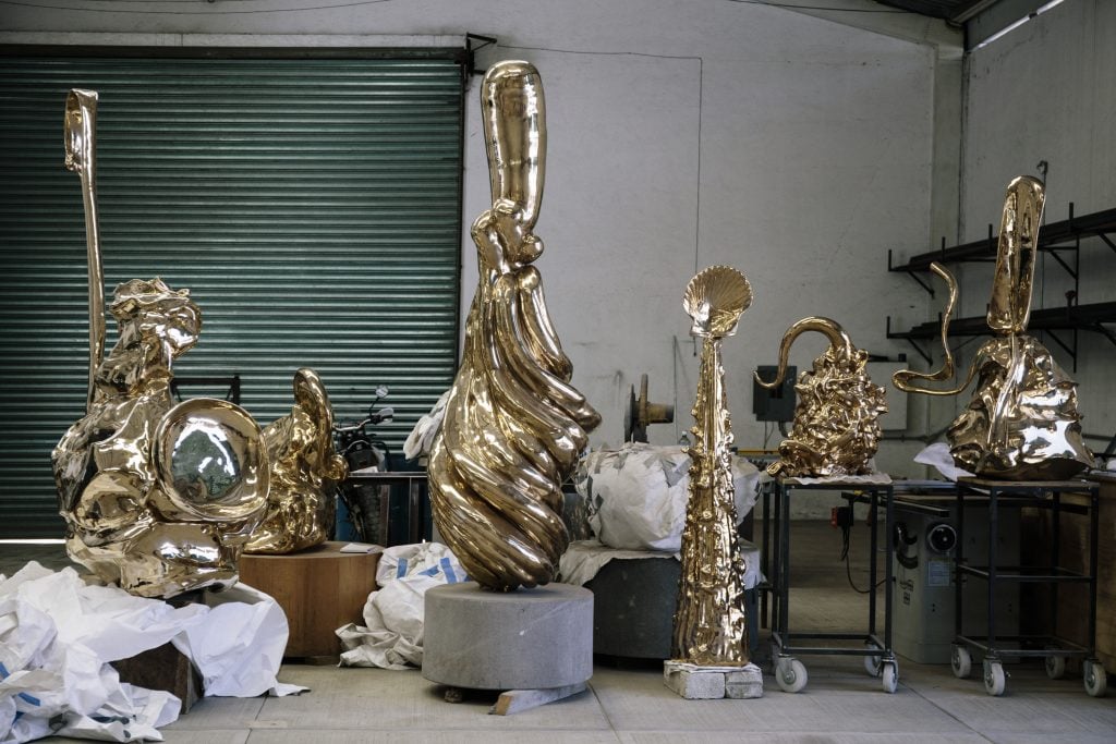 阿尔玛·艾伦工作室的内景，卷帘门前摆满了青铜雕塑。
