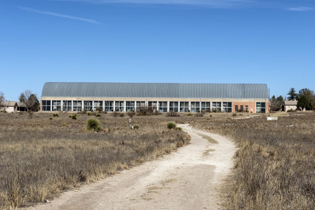 A long warehouse at the end of a gravel path