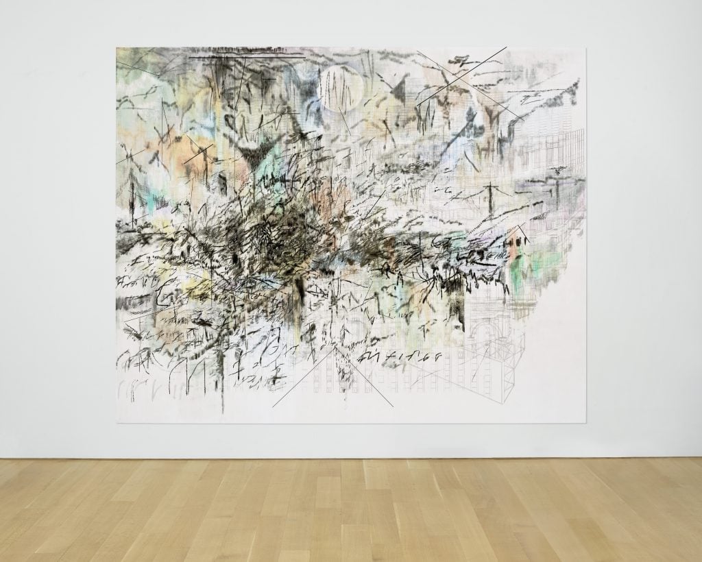 A color photo shows an abstract, intricate painting on a white wall above a wood floor.