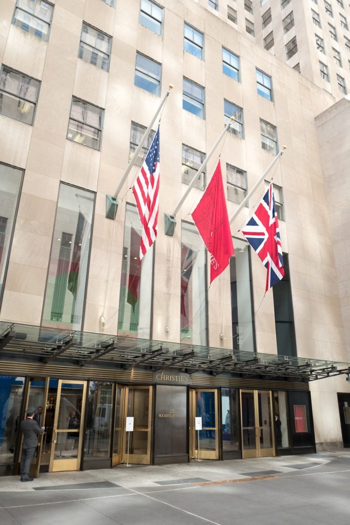 A building housing auction house Christie's, with three flags hanging above its entrance