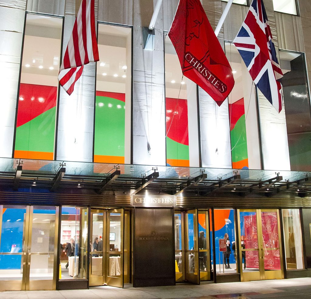 The grand exterior of Christie's New York, featuring three flags
