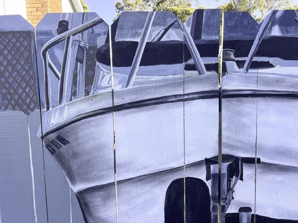 A fence with a boat painted on it