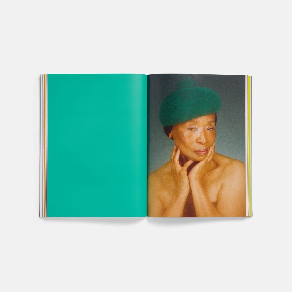 A book opened to a page showing a woman, her fingers to her face, wearing a green beret