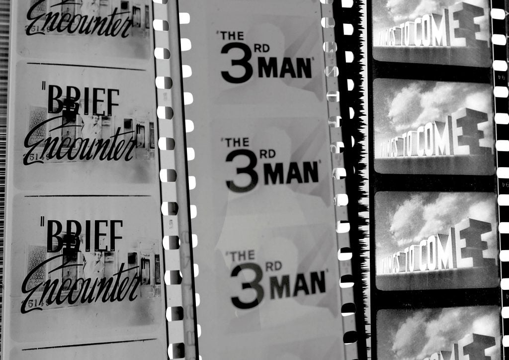 Three black and white film reels showing titles that read 