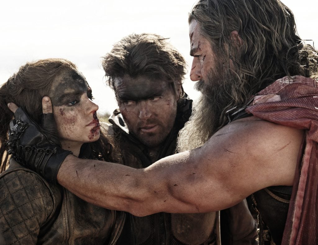 Actors Anya Taylor-Joy, Tom Burke, and Chris Hemsworth in a still from the film Furiosa: A Mad Max Saga
