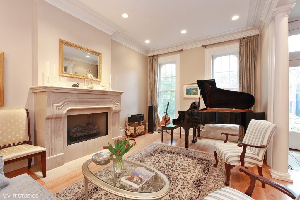 A living room with fancy furnishings and a piano