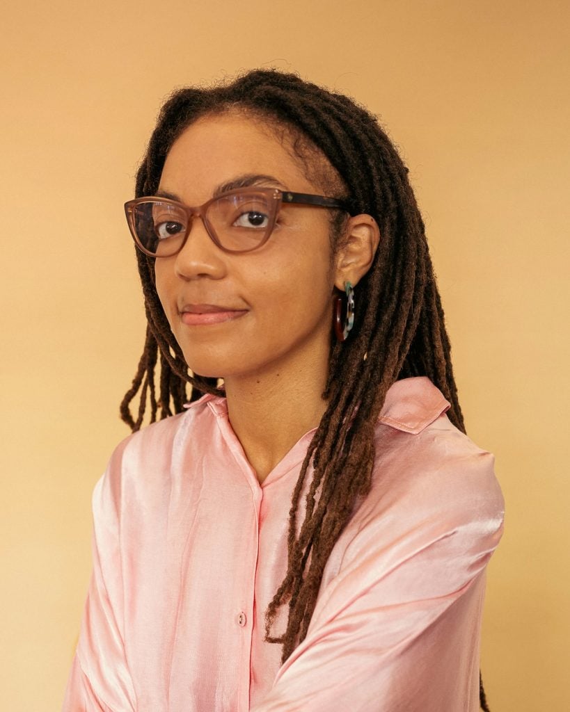 a photo of a woman in a pink shirt and glasses