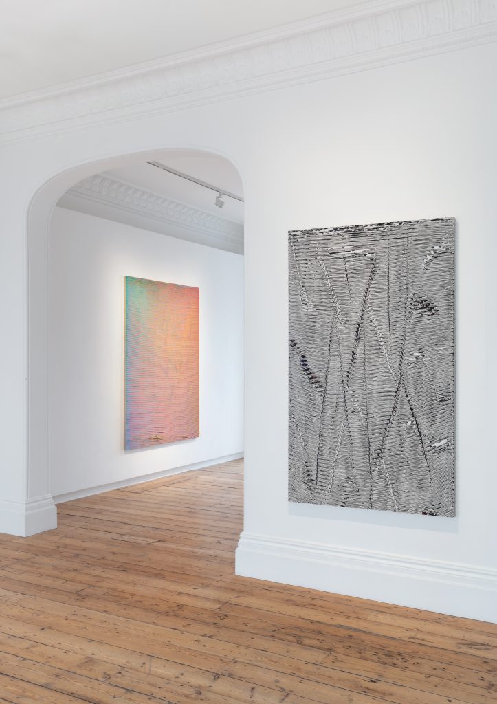 Installation view of Loriel Beltran solo exhibition, showing two abstract paintings within the gallery.