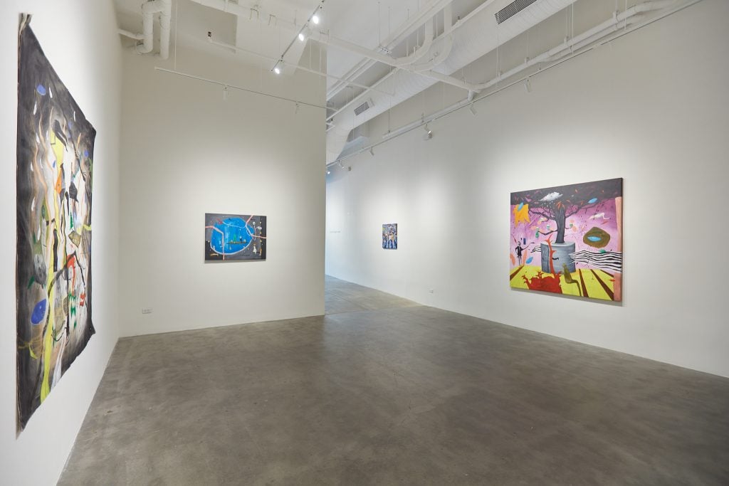 Installation view of four paintings by Johan Galue inside a white gallery space.