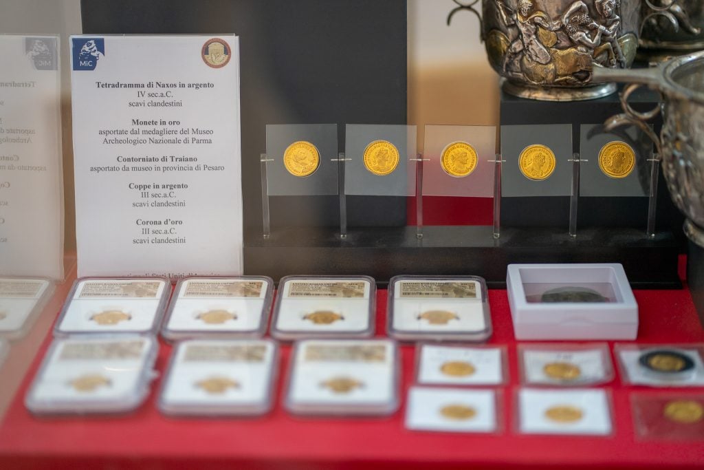 Coins in boxes arrayed on a table