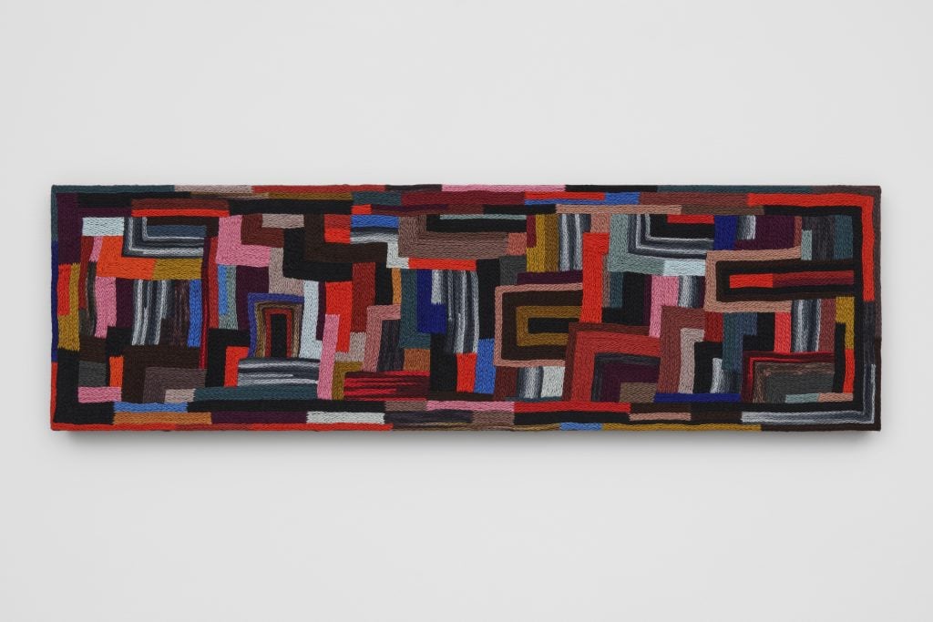 A geometric abstract embroidery in a rectangle by Jan Wade.