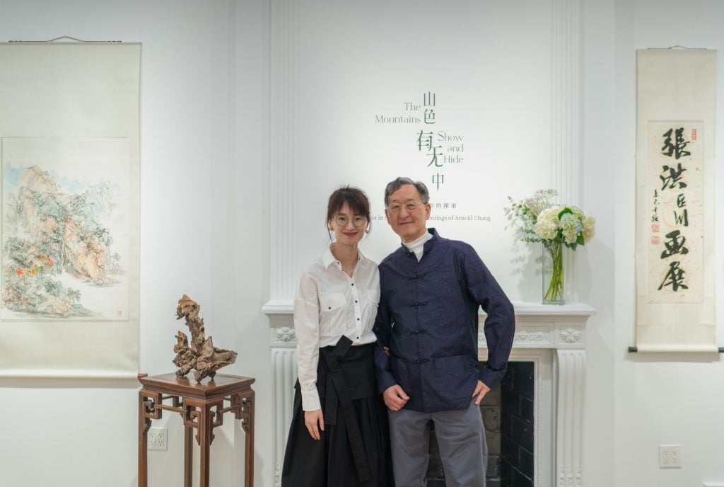Curator Joy Xiao Chen and artist Arnold Chang Fu standing together in the exhibition at Fu Qiumeng Fine Art.
