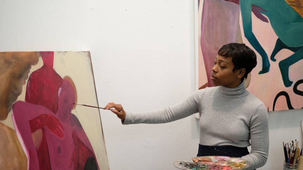 Artist Naudline Pierre at work on a painting