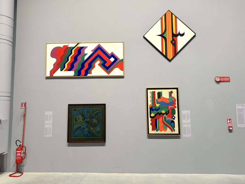 A wall full of various abstract paintings