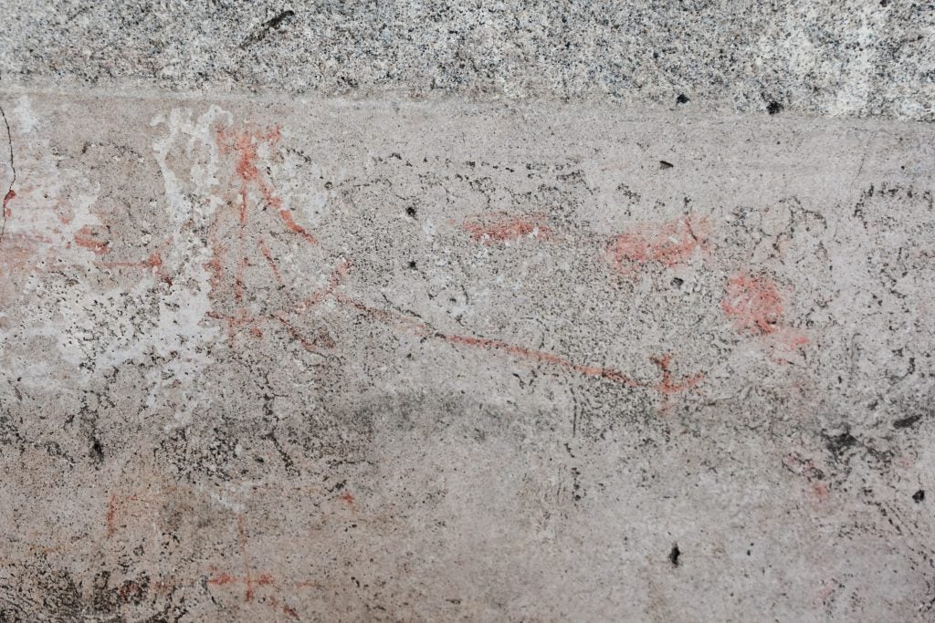 A faint drawing in ocher on a stone wall