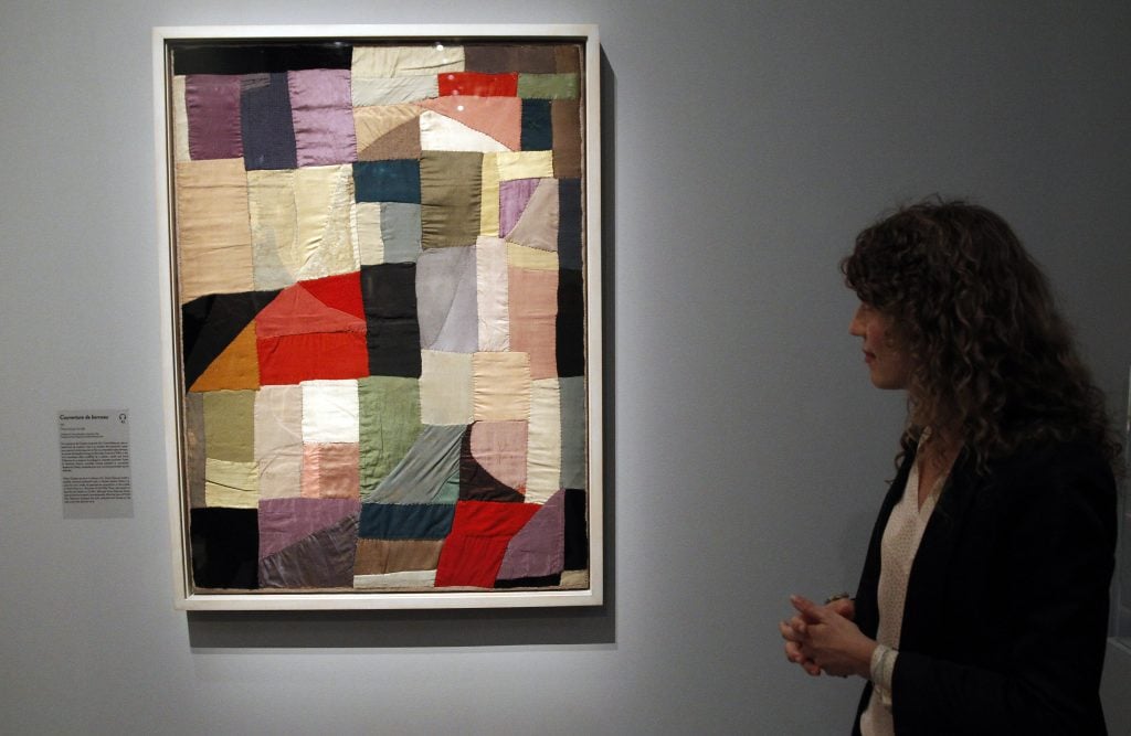 A visitor looks at an abstract artwork by French artist Sonia Delaunay during the press day at Museum of Modern Art