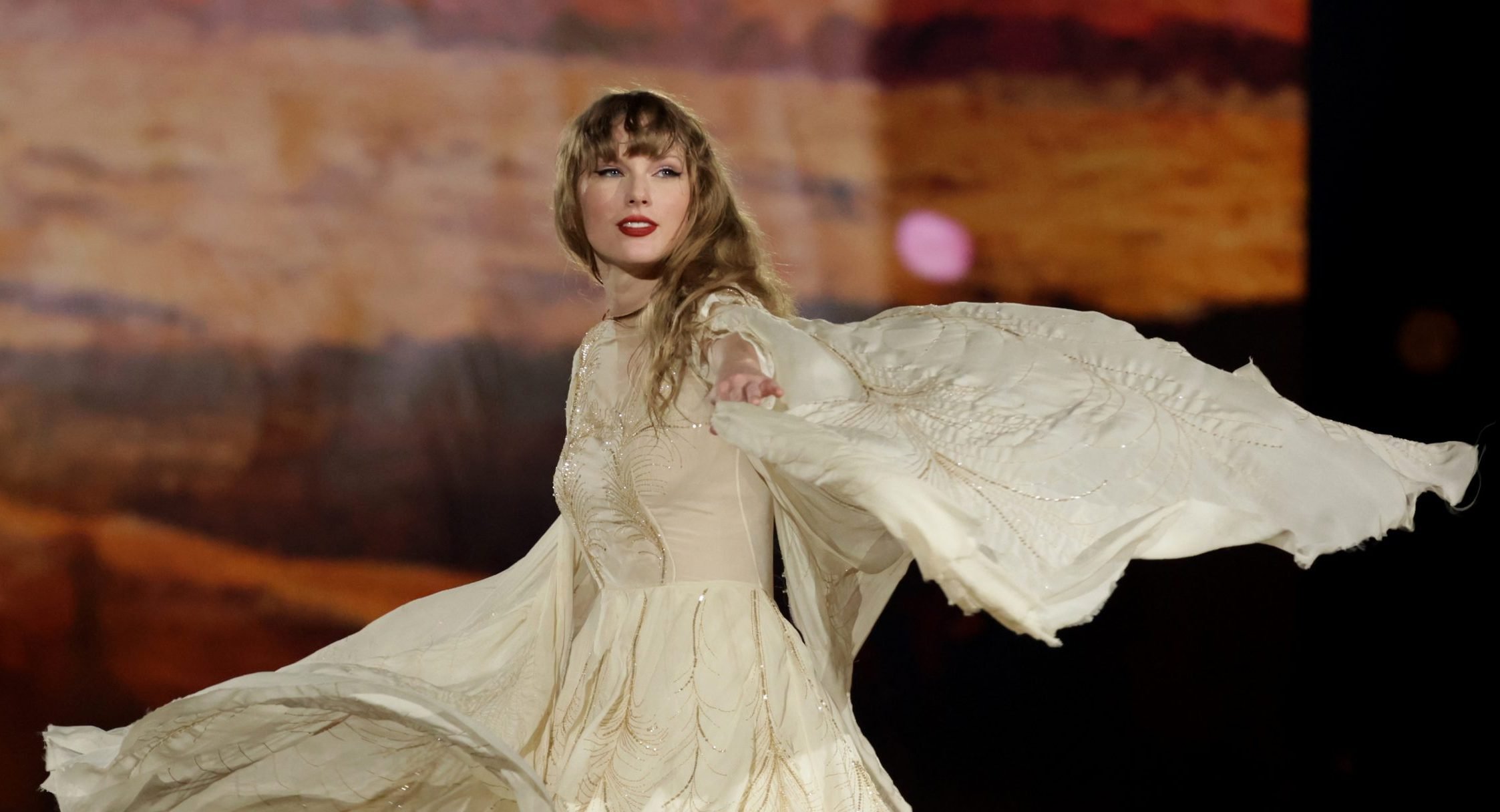 picture of a woman swirling around in a white dress on a stage