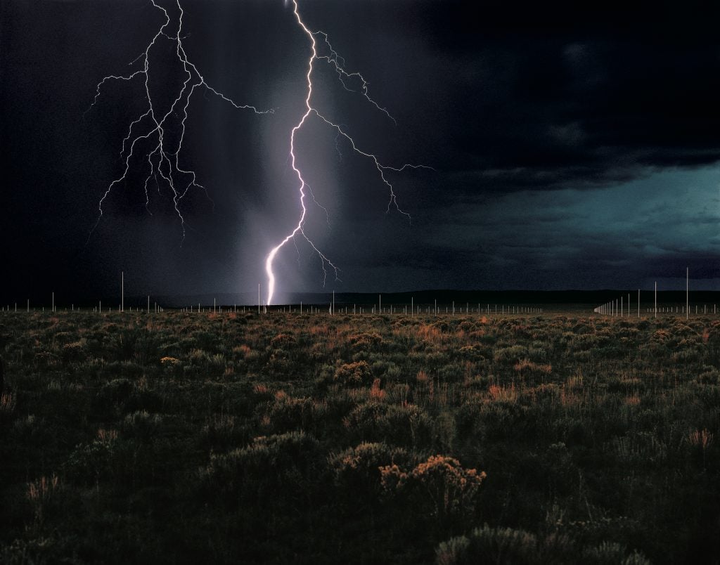 Lighting strikes the horizon across a western new mexico desert dotted with lighting rods, part of Dia Art Foundation site of Walter De Maria's artwork.
