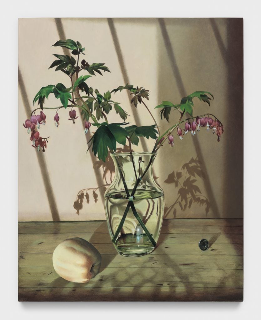 A still life of a clear glass vase with bleeding hearts, beside are a pale apple on one side and an upright quarter on the other