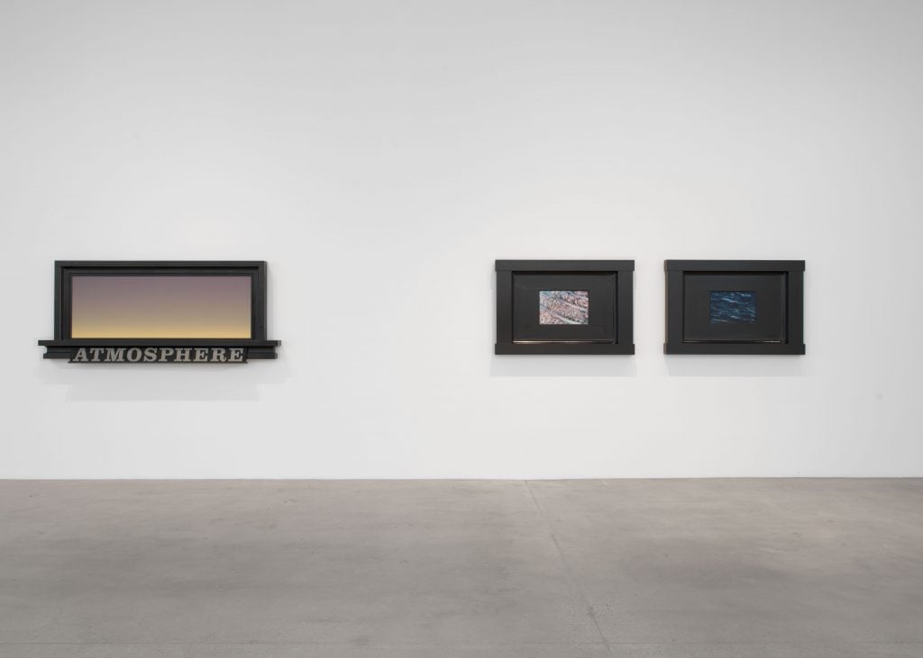 A color photo shows three paintings on a wall—the largest an alluring gradient