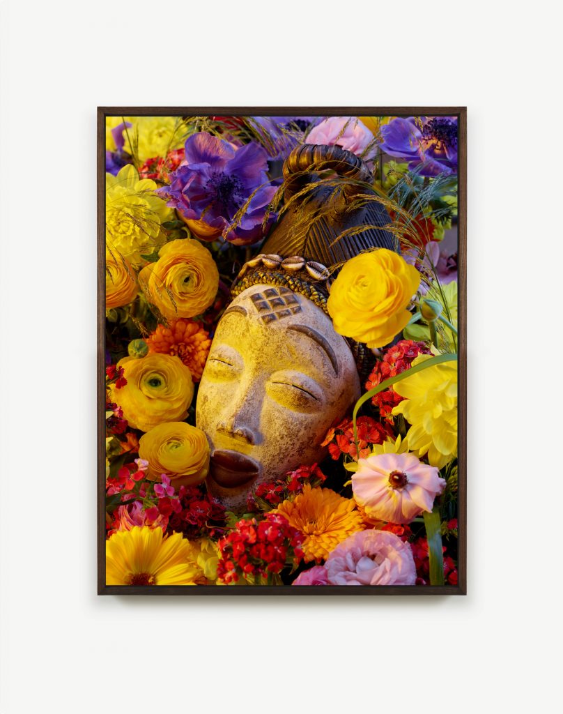 an image of a stone head surrounded by flowers