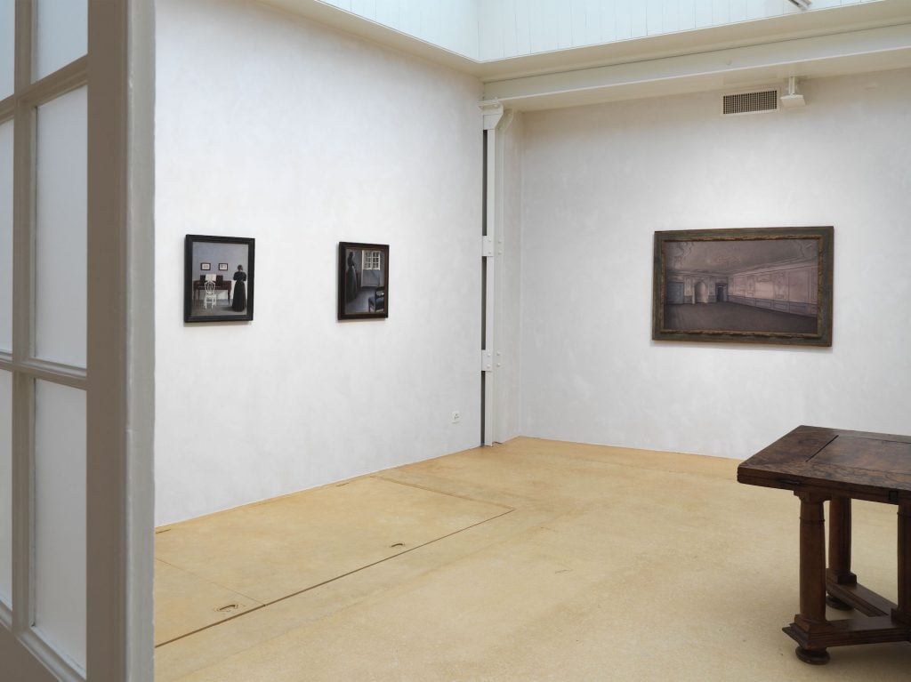 an image showing three paintings by Vilhelm Hammershoi installed at Hauser and Wirth gallery in Basel Switzerland