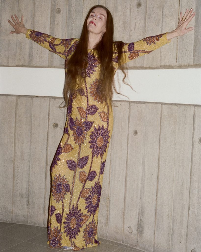 the artist Linder basks against the wall in sequined floral dress 