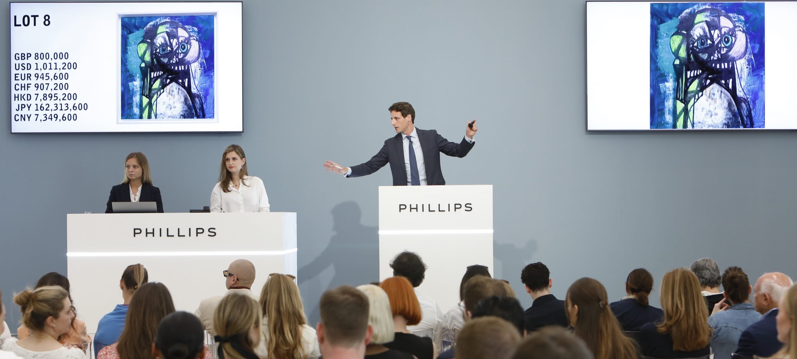 An auctioneer selling an artwork in a saleroom